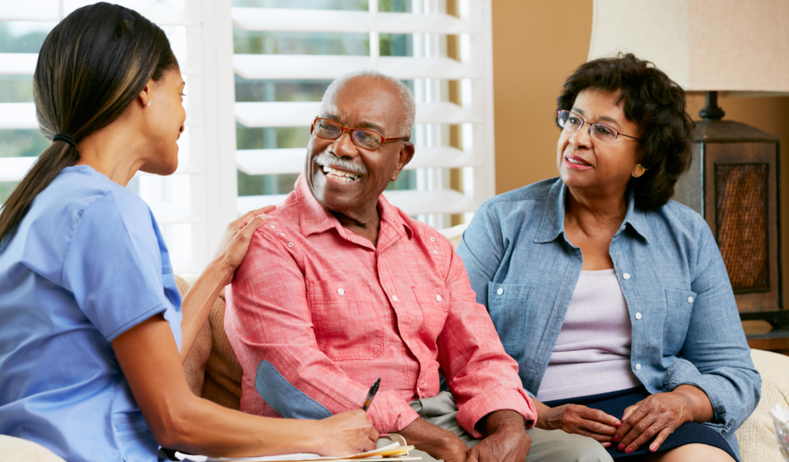 Caregiver sitting with wife and husband discussing care